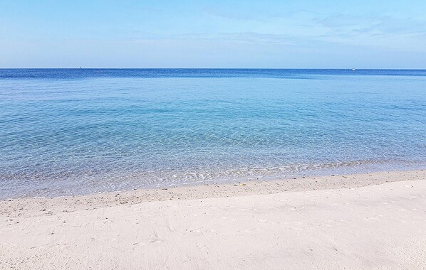 Une plage à l’eau claire et au rivage sablonneux.