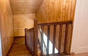 Un escalier en bois, doté d’une rampe, mène à un palier.