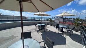 A rooftop patio with outdoor seating, a pool, and a view of the ocean. - ORA BEACH RESIDENCE  (Ipojuca)