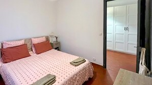 A bedroom with a bed, pillows, a nightstand, a lamp, and a wooden table. - 3 bedroom pet friendly home in Vence (Vence)
