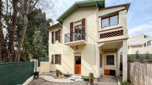 A two-story building with a balcony, a wooden door, and a small porch area. - 3 bedroom pet friendly home in Vence (Vence)
