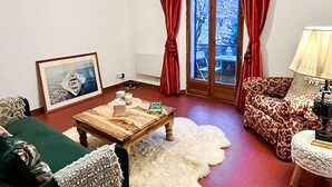 A living room with a wooden coffee table, a framed picture, a patterned sofa, and a lamp. - 3 bedroom pet friendly home in Vence (Vence)