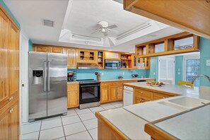 Une cuisine moderne avec des meubles en bois, des appareils électroménagers en acier inoxydable et une grande fenêtre.