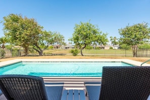 A swimming pool with two wicker lounge chairs facing it, surrounded by trees and a fence. - Villa MeMe with private pool  - 89BP (Laguna Vista)