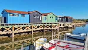 A pier with colorful wooden buildings, a dock with boats, and calm water.