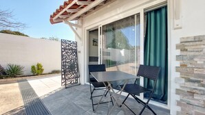 A patio with a table and chairs, a sliding glass door, and a decorative metal fence. - 1 bedroom beautiful home in Rivedoux-Plage (Rivedoux-Plage)