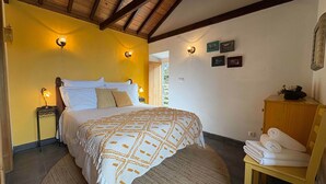 Un dormitorio con cama, lámparas de noche, un armario de madera y un tapete redondo.