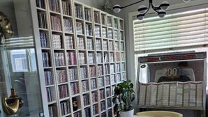 A room with a white table and chairs, a bookshelf filled with books, a potted plant, and a vending machine. - Modern 1-bedroom apartment w/Pool in Popular Northpark Neighborhood (San Diego)