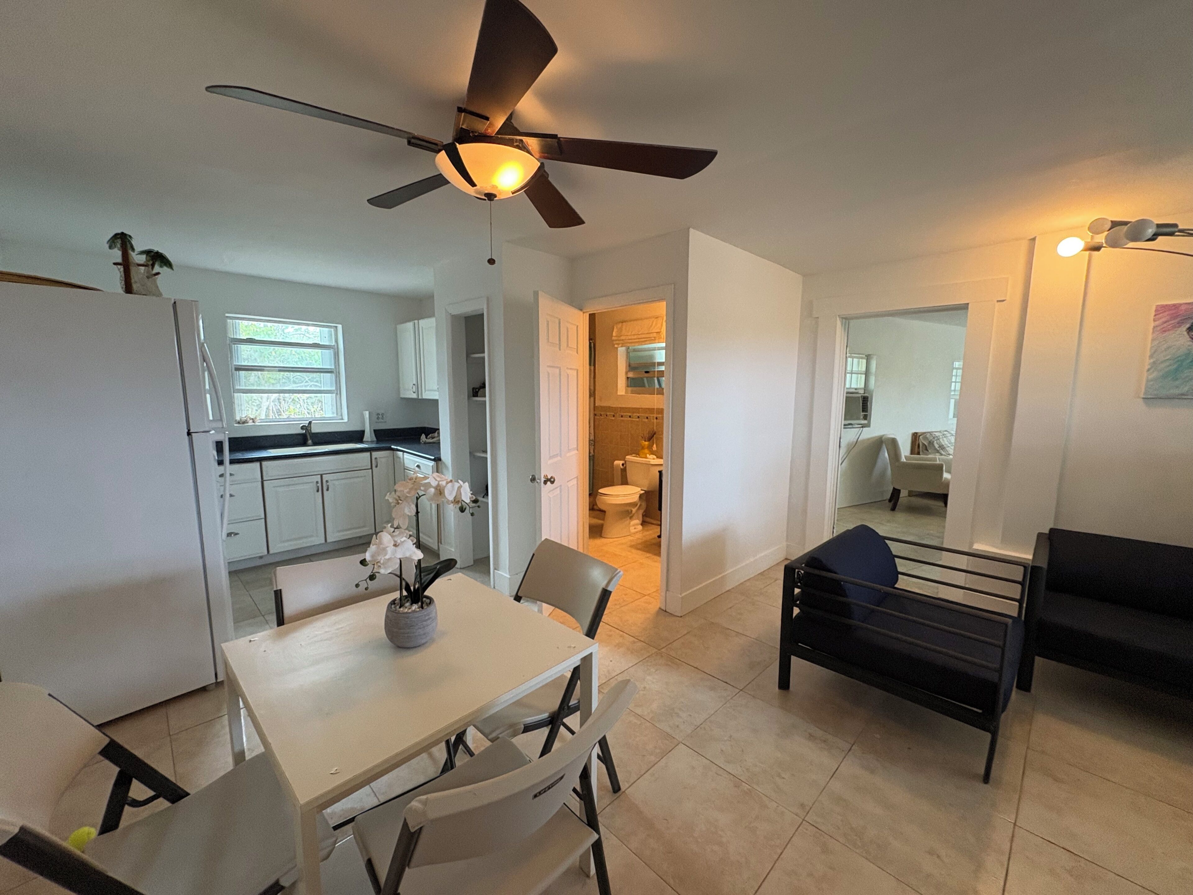 Un espacio habitable compacto con comedor, kitchenette y un dormitorio.