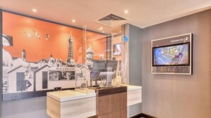 Een hotel lobby met een groot ijserdisplay, een bewakingscamera en een Premier Inn bord.