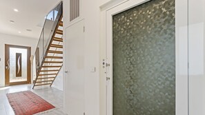 Ein modernes Interieur mit einer Treppe, einer Tür mit Muster und einem roten Teppich.