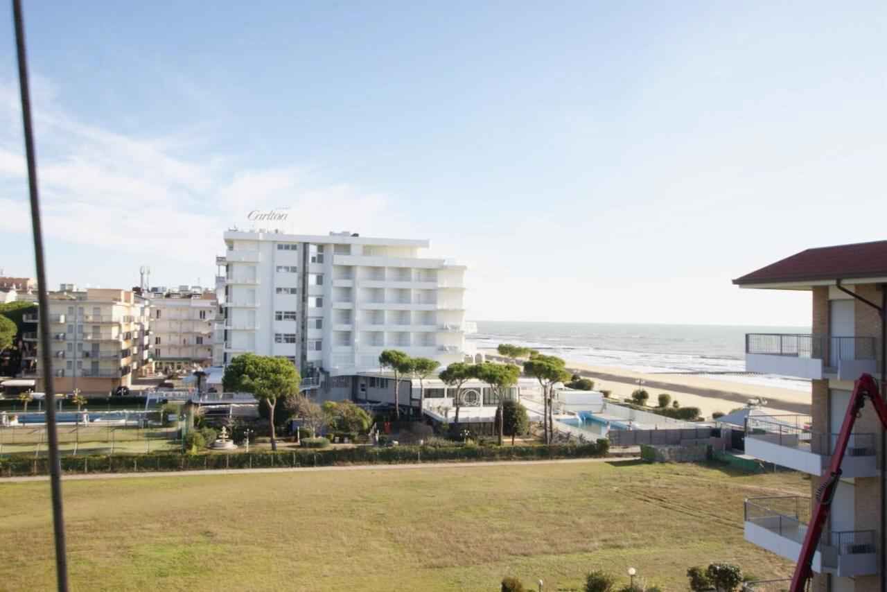 A coastal hotel with multiple floors, a beach view, and a parking area.