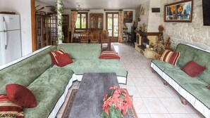 Ein Wohnzimmer mit grünen Sofas, einem Couchtisch und einem Kamin.