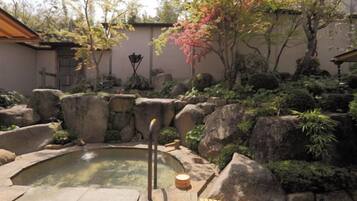A hot spring surrounded by rocks and plants.