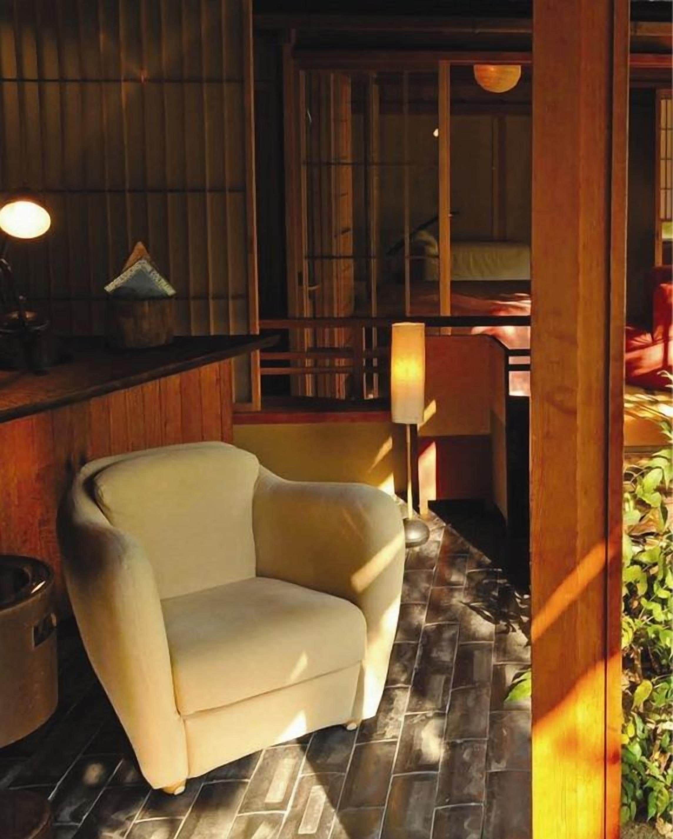 A room with a sofa, a table, and a lamp.