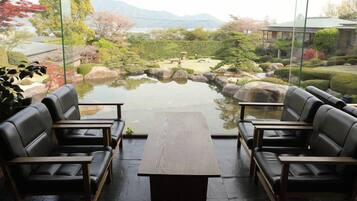 A room with a view of a garden, a table, and four chairs.