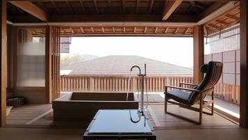 A traditional Japanese room with tatami flooring, a low table, a cushioned bench, and a view of a mountain.