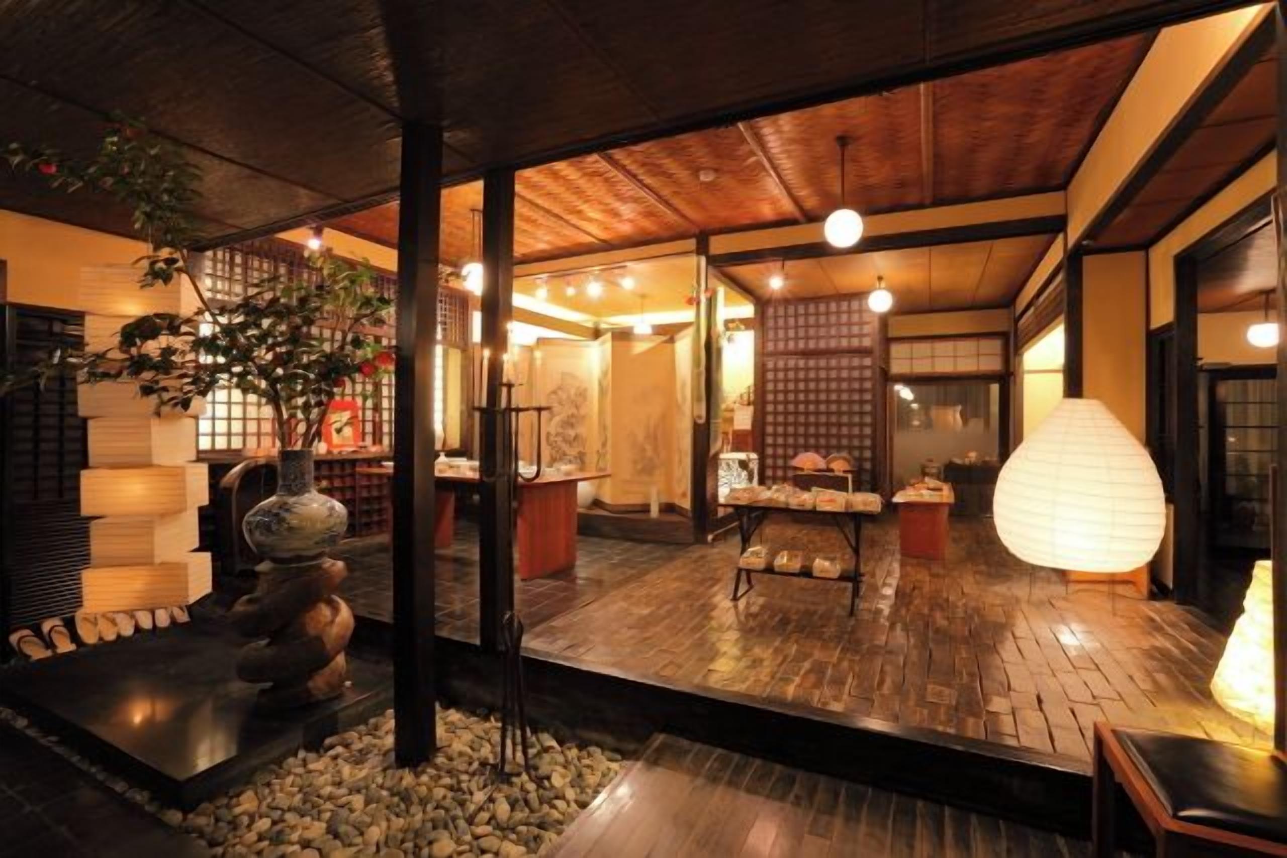 A traditional Japanese interior with tatami flooring, a shoji screen, and a stone lantern.