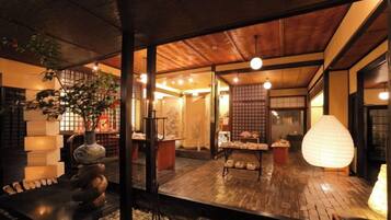 A traditional Japanese interior with tatami flooring, a shoji screen, and a stone lantern.
