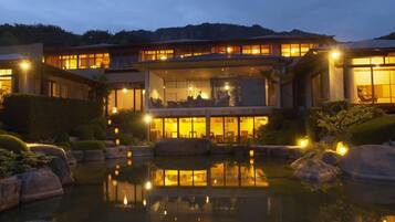 A modern hotel with a large pool and multiple rooms with large windows.