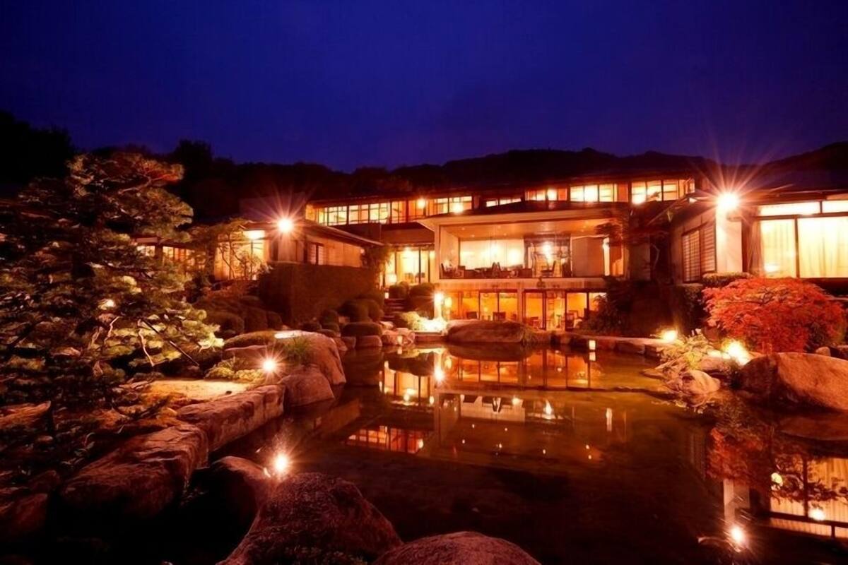 A traditional Japanese-style building with a koi pond, surrounded by rocks and plants.