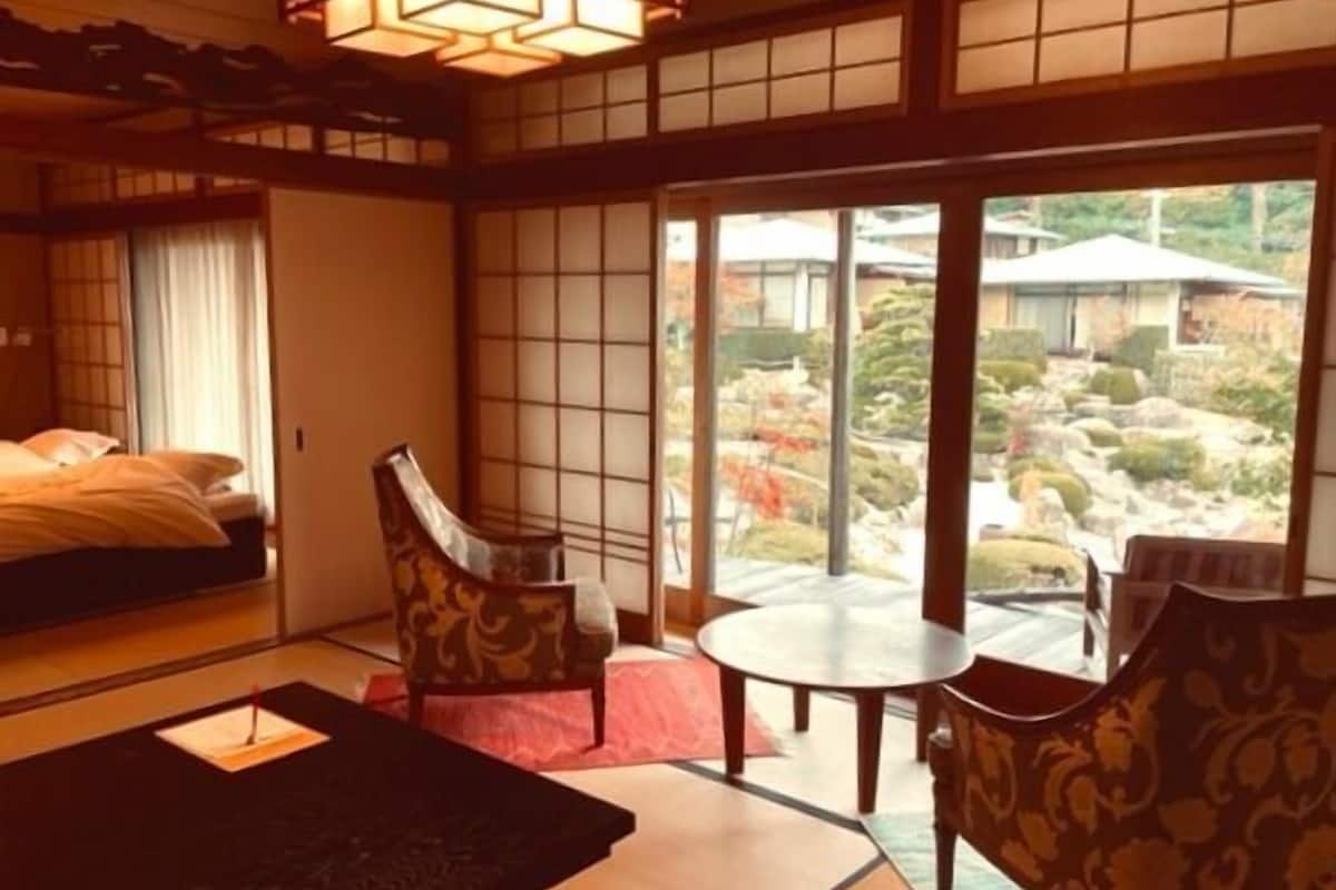 A traditional Japanese-style room with tatami flooring, a low table, and chairs.