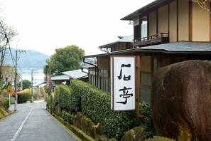 A traditional Japanese building with a signboard and a stone pathway. - Miyahama Onsen Teien no Yado Sekitei (Hatsukaichi)