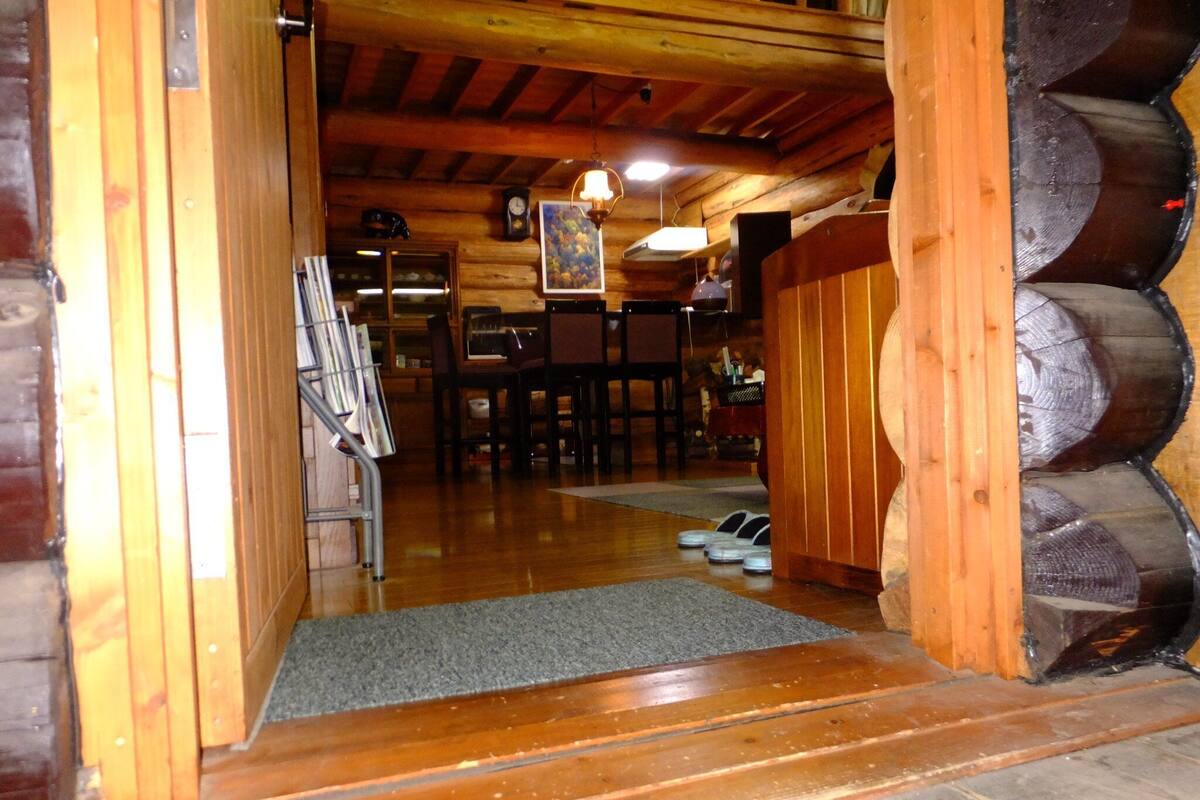 A wooden interior with a staircase leading to a dining area.