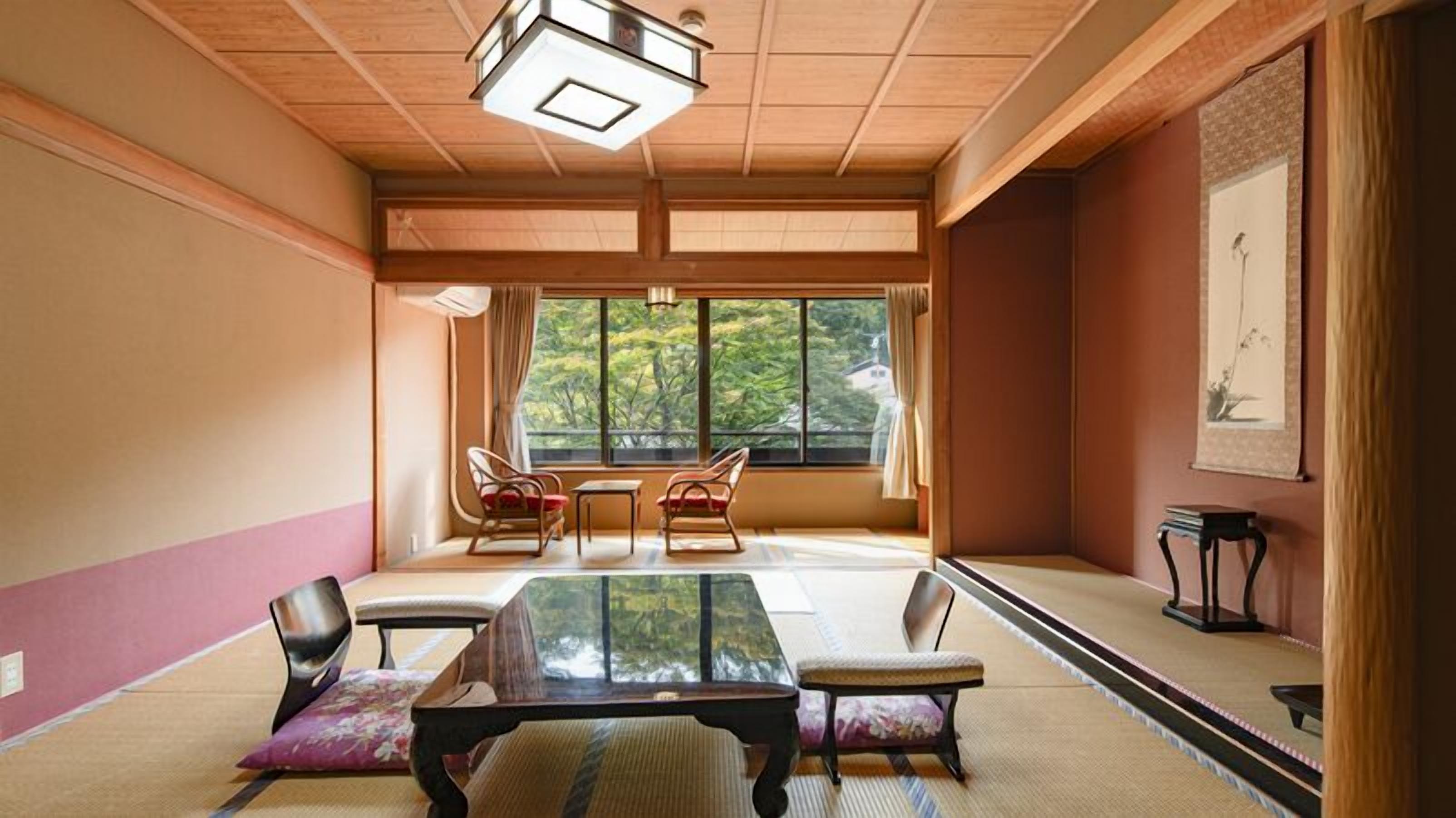 A traditional Japanese room with tatami flooring, a low table, and chairs.