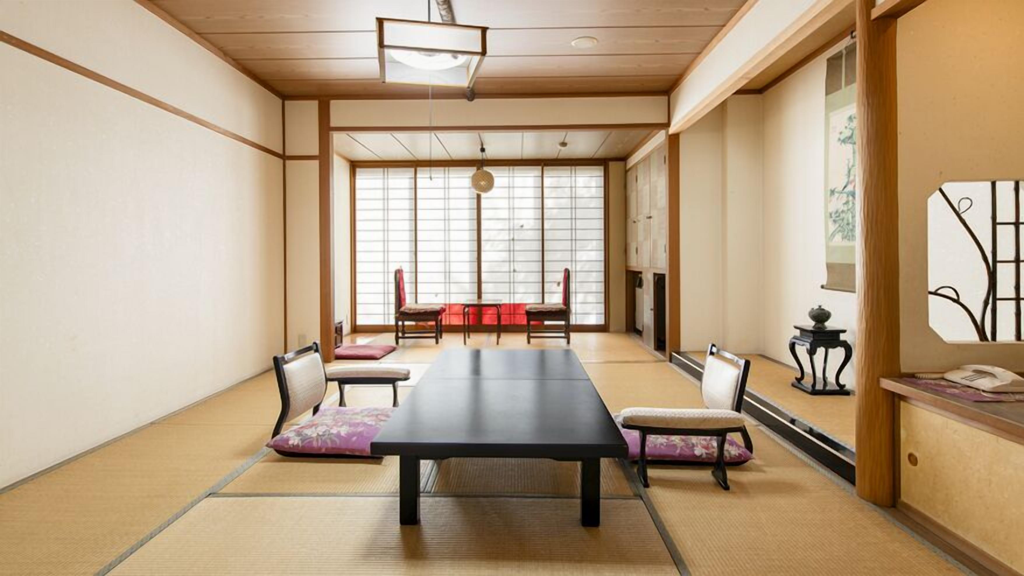 A traditional Japanese room with tatami flooring, a low table, and shoji screens.