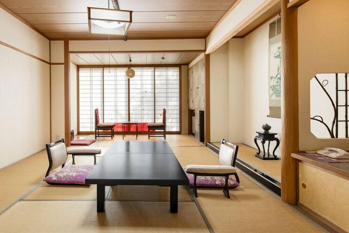 A traditional Japanese room with tatami flooring, a low table, and shoji screens.