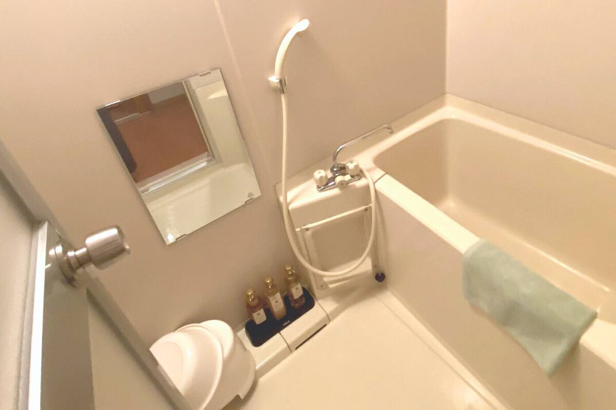 Un baño con bañera, inodoro y espejo.