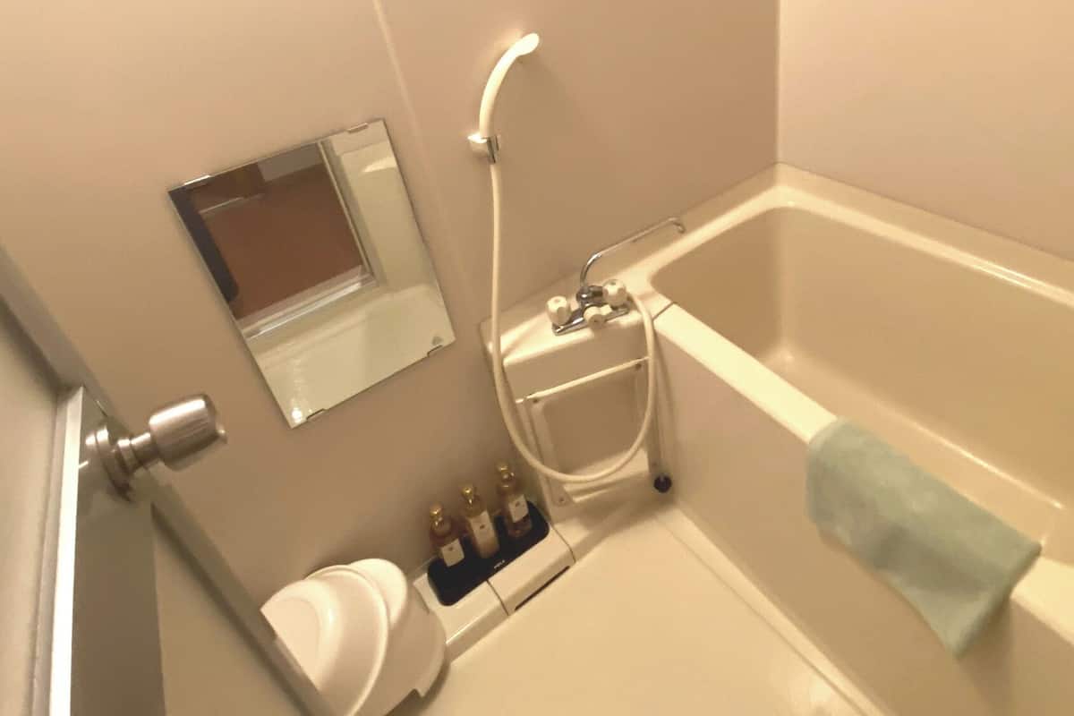 Un baño con bañera, inodoro, lavamanos y espejo.