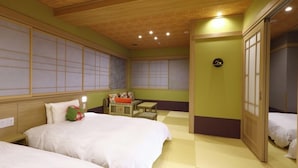 A traditional Japanese-style room with tatami flooring, a futon bed, a low table with cushions, and sliding doors. - Dandan No Yu Onyado Nono Matsue (Matsue)