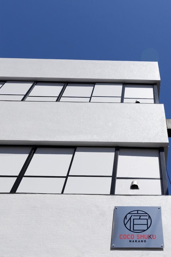 A building with a sign reading 'COCO SHUKU NAKANO' and a grid of windows. - Coco Shuku Nakano (Tokyo)