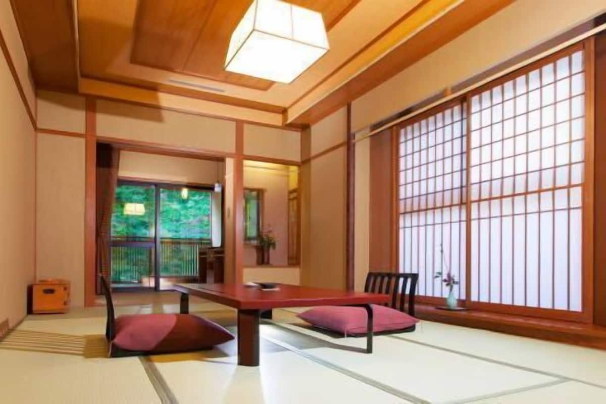 A traditional Japanese room with tatami flooring, a low wooden table, and shoji screens.