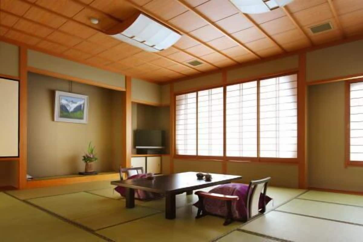 A traditional Japanese room with tatami flooring, a low table, and sliding doors.