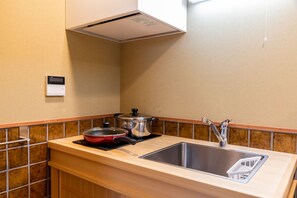 A compact kitchen with a sink, a stove, and a range hood. - Mibu Dodan Momiji (Kyoto)