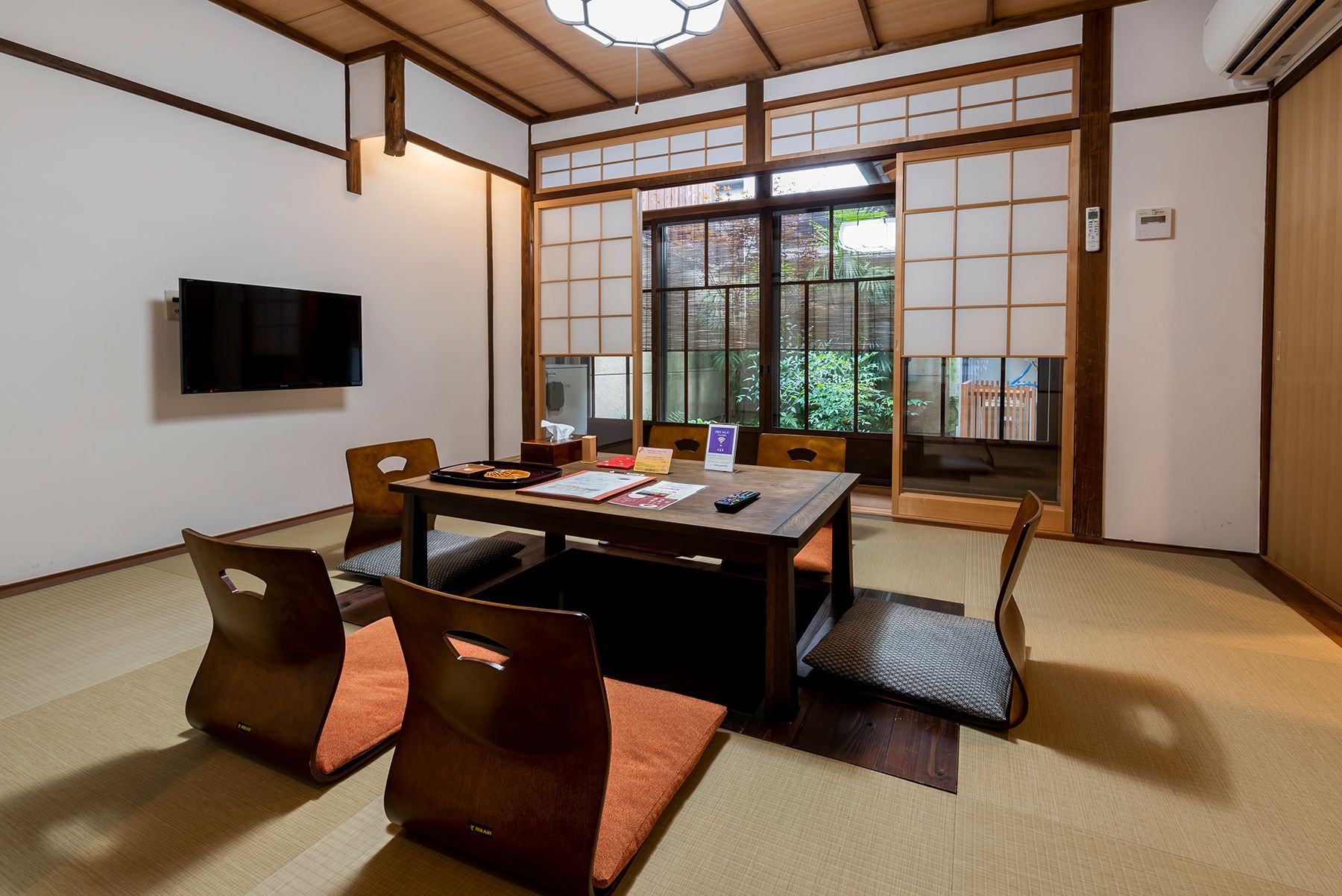 Habitació japonesa tradicional amb tatami, una taula baixa i panells shoji.