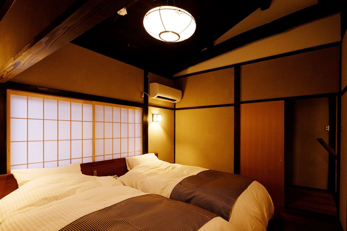 Ein traditioneller japanischer Raum mit Tatami-Bodenbelag, niedriger Holzbalkendecke und Shoji-Schirm.