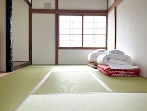 Ein traditioneller japanischer Raum mit Tatami-Bodenbelag, Shoji-Schirm und Futonbetten.