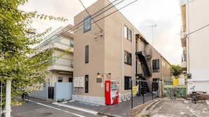 A building with a fire escape, a Coca-Cola vending machine, and a bicycle parked outside. - Grandioso Urban Stay Shinjuku East (Tokyo)