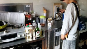 A kitchen with a gas stove, a coffee maker, and various kitchen utensils. - Moritomizu Backpackers (Nagano)