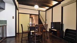 A dining area with a wooden table and chairs, a television, and a staircase leading to another room. - Kyo no Katadomari Kiyomizu Birodo-an (Kyoto)