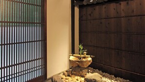 A traditional Japanese interior with tatami flooring, a shoji screen, and a rock garden with a bonsai tree. - Kyo no Katadomari Kiyomizu Birodo-an (Kyoto)
