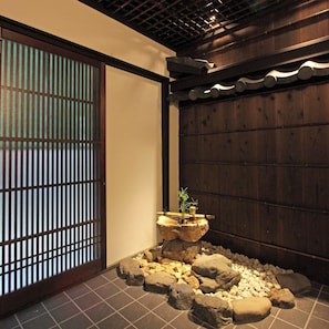 A traditional Japanese interior with tatami flooring, a shoji screen, and a rock garden with a bonsai tree. - Kyo no Katadomari Kiyomizu Birodo-an (Kyoto)