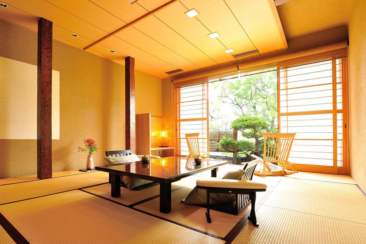 A traditional Japanese room with tatami flooring, a low table, and sliding doors.