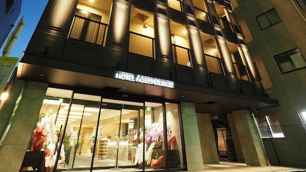 Entrada de un hotel con un cartel que dice 'HOTEL ABEST GRANDE'.