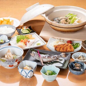 Une variété de plats japonais, notamment des sushis, des sashimis et des bols de riz.