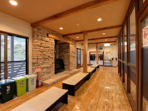 A long corridor with benches, a stone fireplace, and a fire extinguisher.